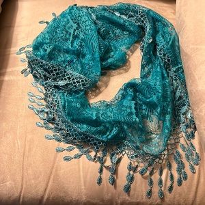 Turquoise circular scarf with fringe.